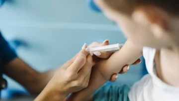 Sağlık kuruluşunda bir çocuğa aşı uygulanırken, aşı kaydı bilgilendirme görseli