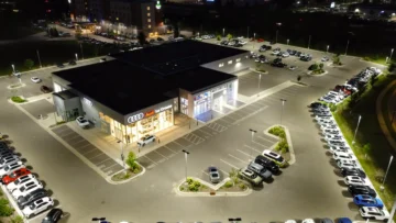 Gece aydınlatılmış otomobil galerisinde satışa sunulan araçlar; ikinci el otomobil satışında motorlu taşıtlar vergisi mükellefiyetinin değişmesini temsil eden fotoğraf