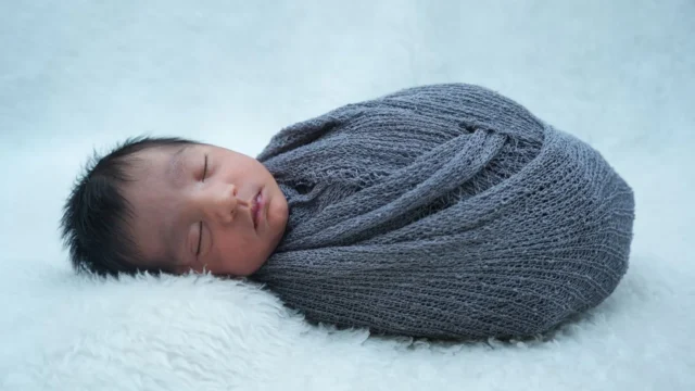 Yumuşak örtü üzerinde uyuyan yeni doğan bebek; 2026 SGK emzirme ödeneği ve süt parası sorgulama rehberi için temsili doğal fotoğraf
