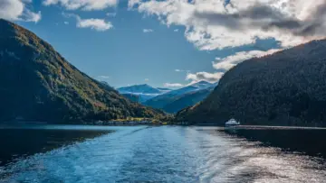 Norveç fiyortlarında yol alan feribot ve dağ manzarası; Aviva ve insureMO'nun Norveç'te başlattığı seyahat sigortası uygulaması için temsili fotoğraf