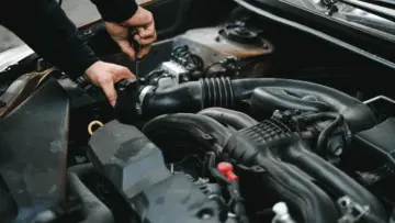 Motor kaputu açık araçta motor ve kabloları inceleyen tamirci; kemirgen nedeniyle kablo hasarının kasko kapsamı için temsili fotoğraf