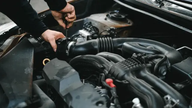Motor kaputu açık araçta motor ve kabloları inceleyen tamirci; kemirgen nedeniyle kablo hasarının kasko kapsamı için temsili fotoğraf