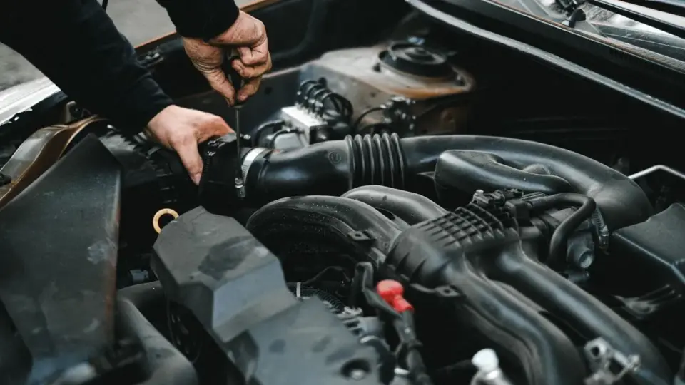 Motor kaputu açık araçta motor ve kabloları inceleyen tamirci; kemirgen nedeniyle kablo hasarının kasko kapsamı için temsili fotoğraf