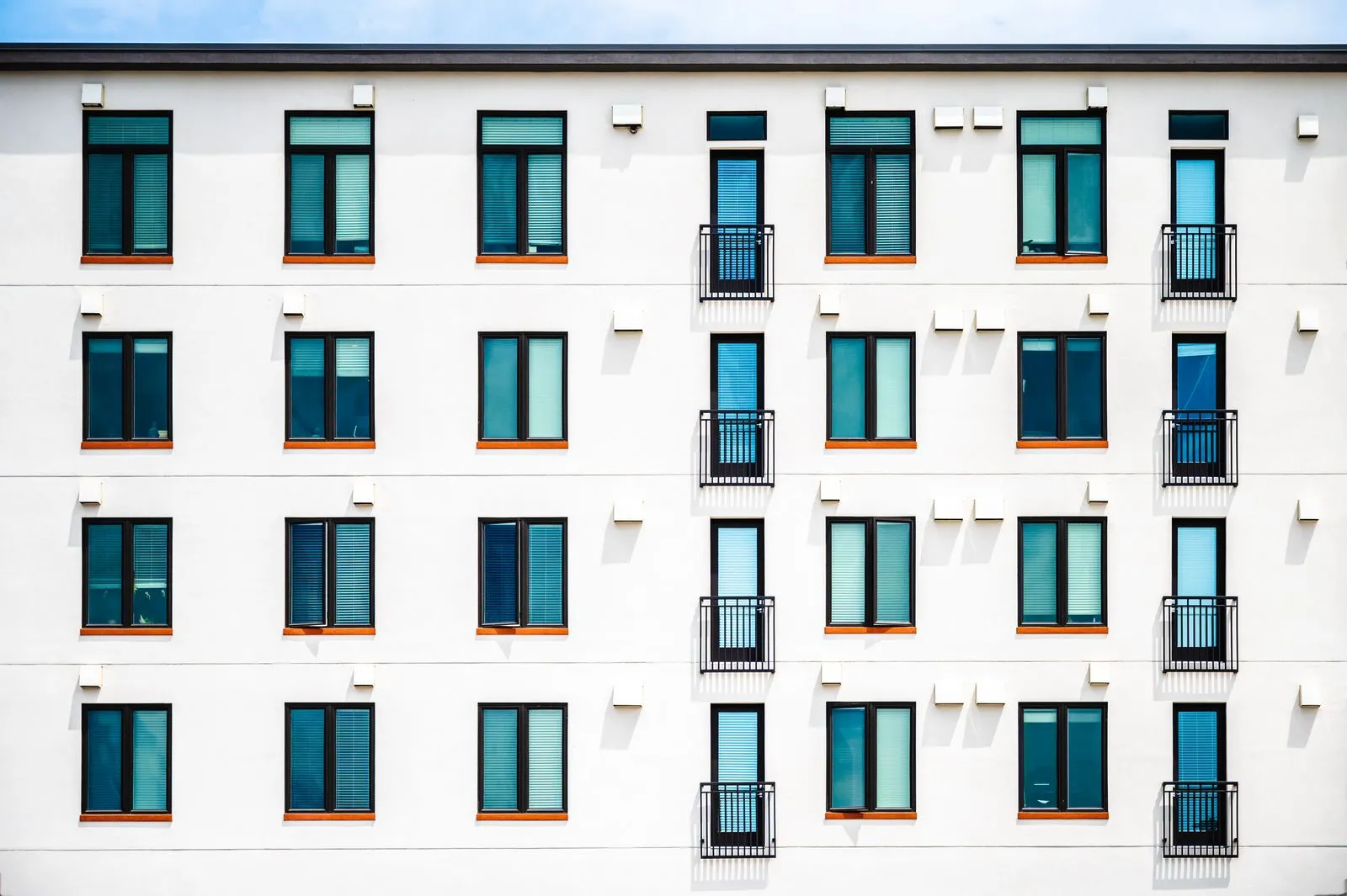 Gün ışığında beyaz cepheli modern apartman binası; binalarda enerji kimlik belgesi ve enerji performansı sınıfı rehberinin temsili görseli