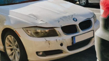 Cadde üzerinde ön tamponu hasar görmüş beyaz otomobil; trafik kazasında yüzde 50 kusur oranı ve tazminat rehberi için temsili gerçek fotoğraf
