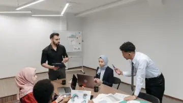Toplanti masasinda bir araya gelen farkli kurumlardan profesyoneller; Roundstone Insurance saglik sigortasi captive katilimcilarina dagitilan tasarruflarla ilgili temsili fotograf