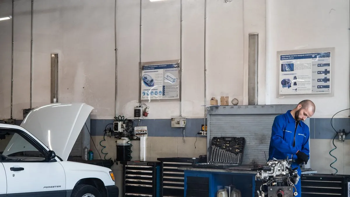 Otomobil servisinde motor bölümünde çalışan teknisyen; CCC Intelligent Solutions'ın hasar ve onarım yazılımı faaliyetlerini temsil eden fotoğraf