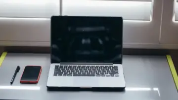 Dizüstü bilgisayarın yanında akıllı telefon, e-Devlet iki aşamalı giriş rehberi görseli