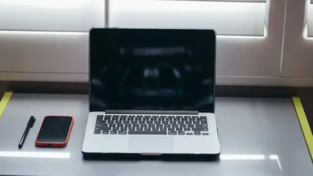 Dizüstü bilgisayarın yanında akıllı telefon, e-Devlet iki aşamalı giriş rehberi görseli