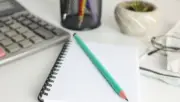 Finansal raporların hazırlanmasında kullanılan hesap makinesi, not defteri ve masa düzeni