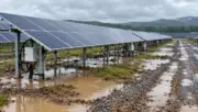 Yağmur sonrasında su birikintileri ve güneş paneli dizileri bulunan enerji santrali; First Solar–Zurich davası temsili