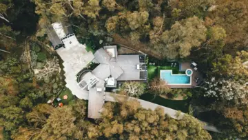 Kaliforniya'da ağaçlarla çevrili lüks konutun havadan görünümü; SageSure One yüksek değerli konut sigortası haberi için temsili fotoğraf